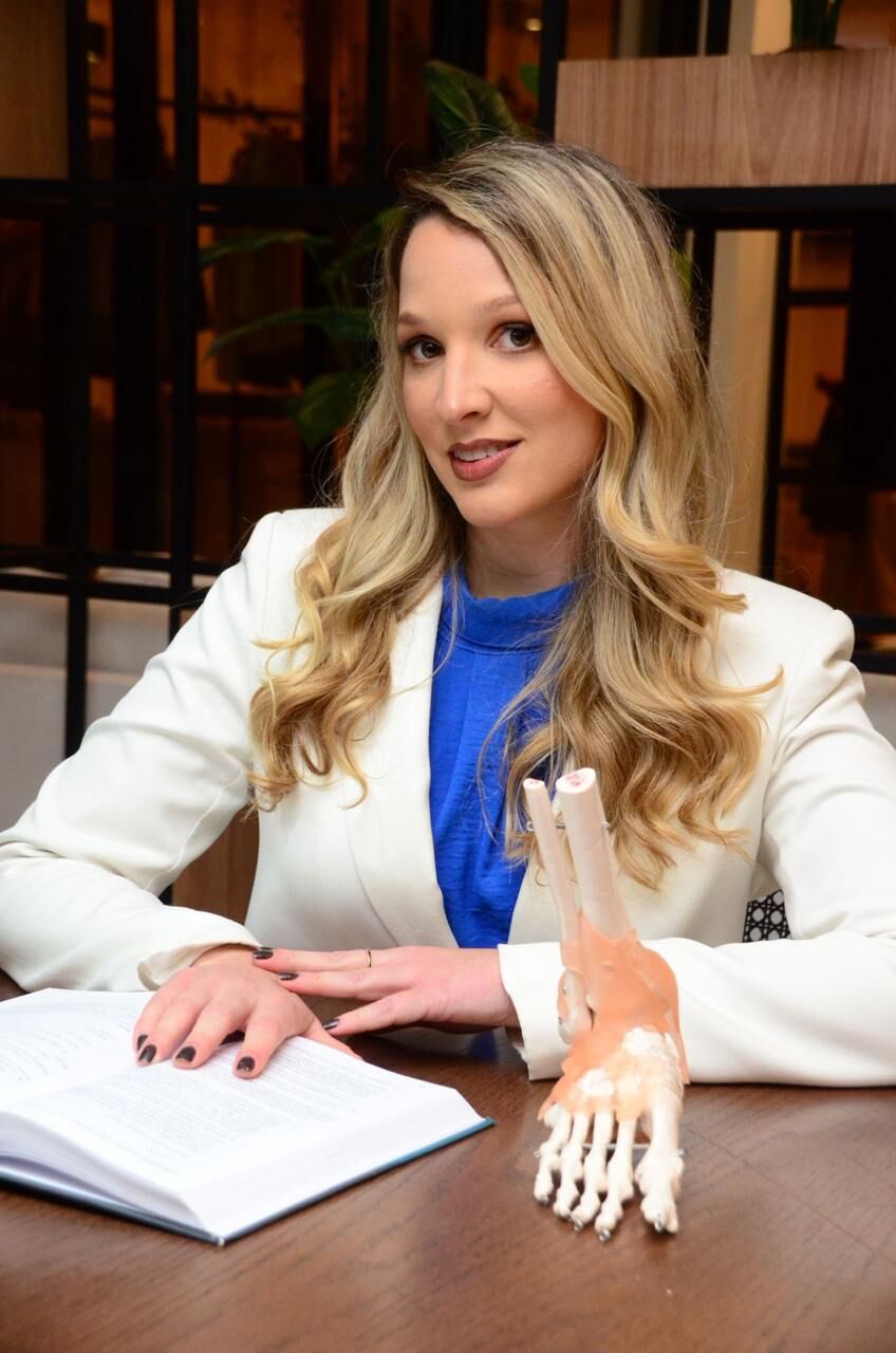 Dra. Elizabeth de Alvarenga Borges da Fonsêca, ortopedista pediátrica, com modelo anatômico de pé